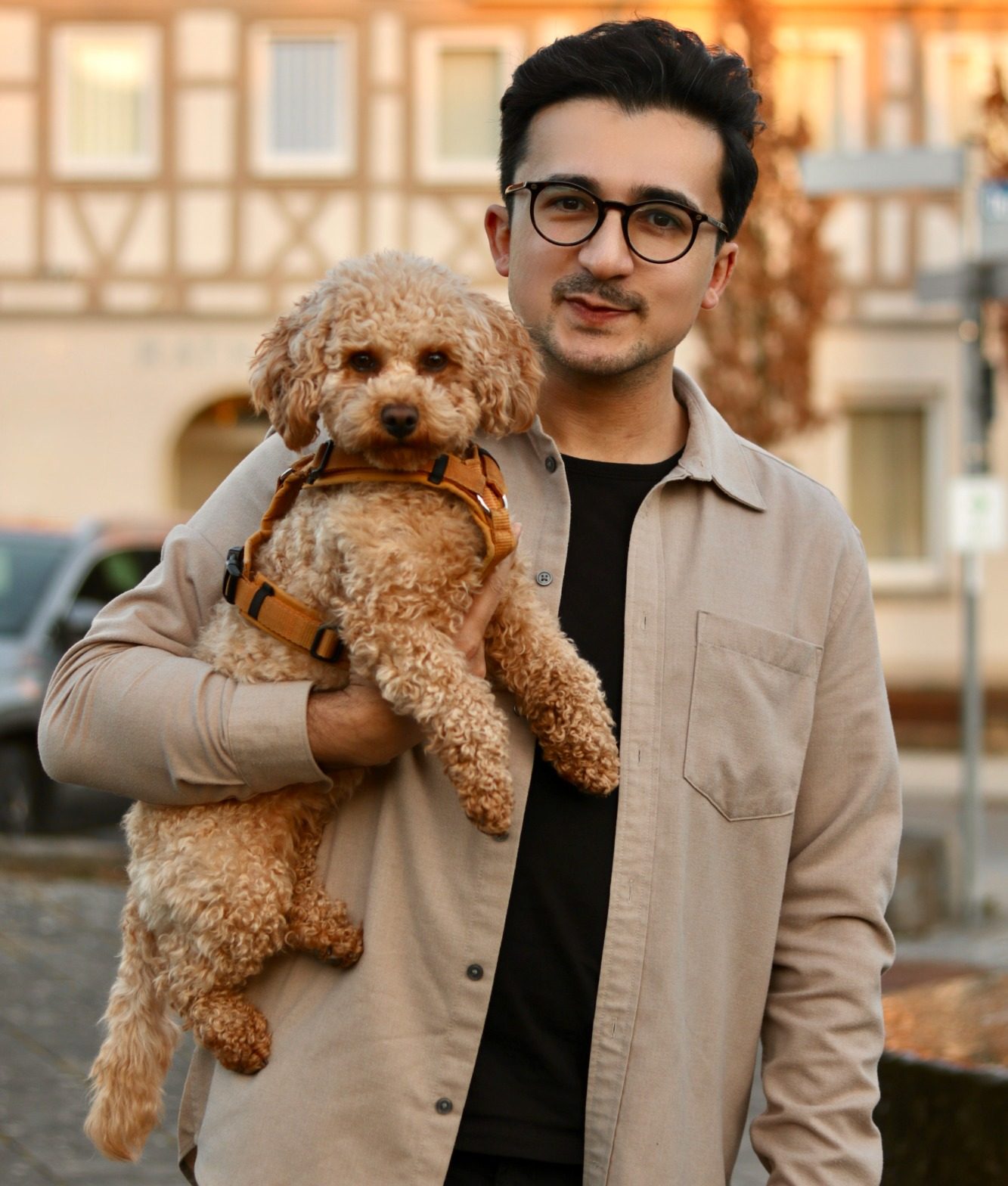 Porträt von Eser Turgut mit einem Zwergpudel unter seinem Arm