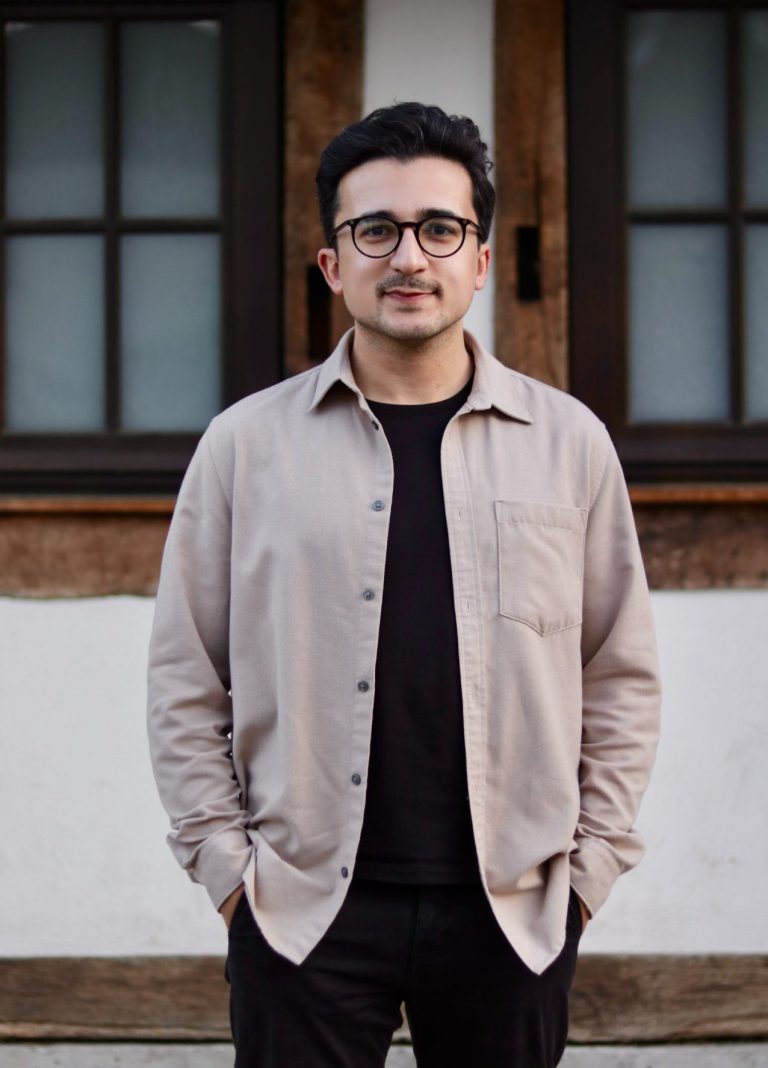 Porträt von Eser Turgut vor einer Wand mit Fenstern